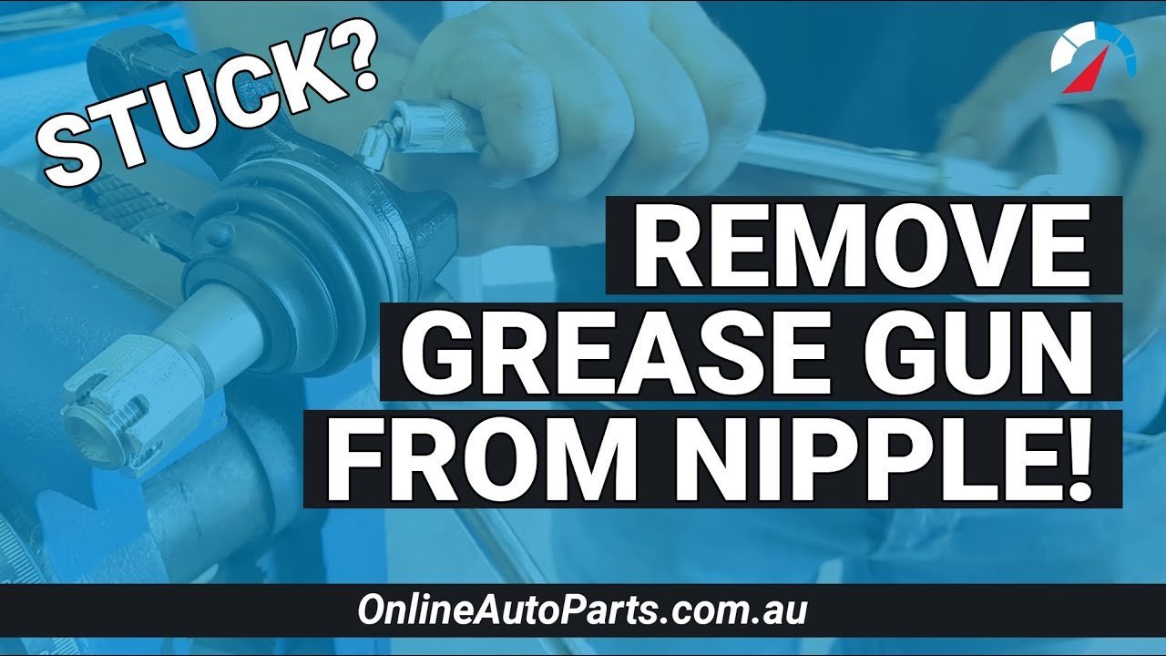 Mechanic preparing to attach a grease gun to a vehicle suspension fitting.